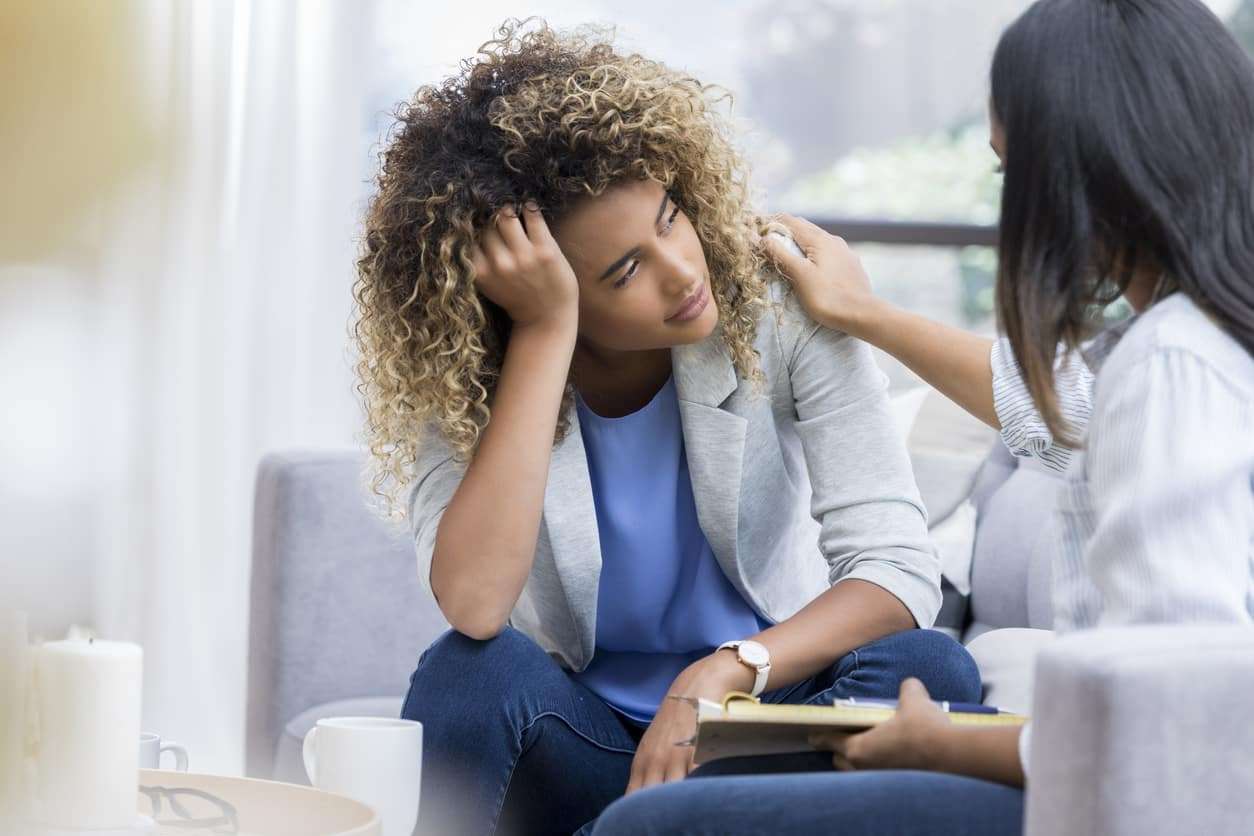 Young woman consulting with her psychiatrist to see if she's eligible for alternative depression treatments.